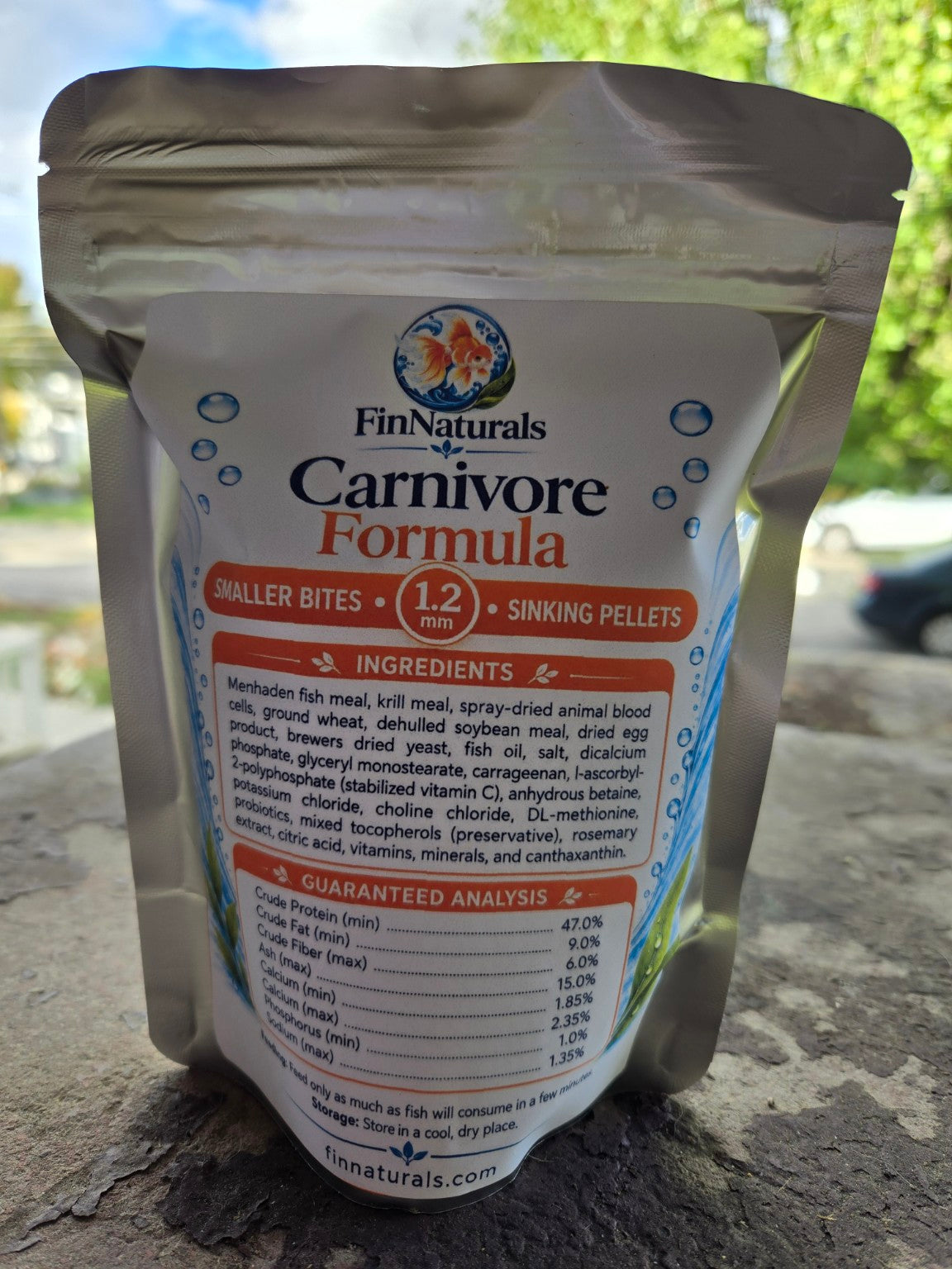 Actual Carnivore Smaller Bites Formula 1.2 mm pouch photographed outdoors, back label with ingredients and guaranteed analysis.