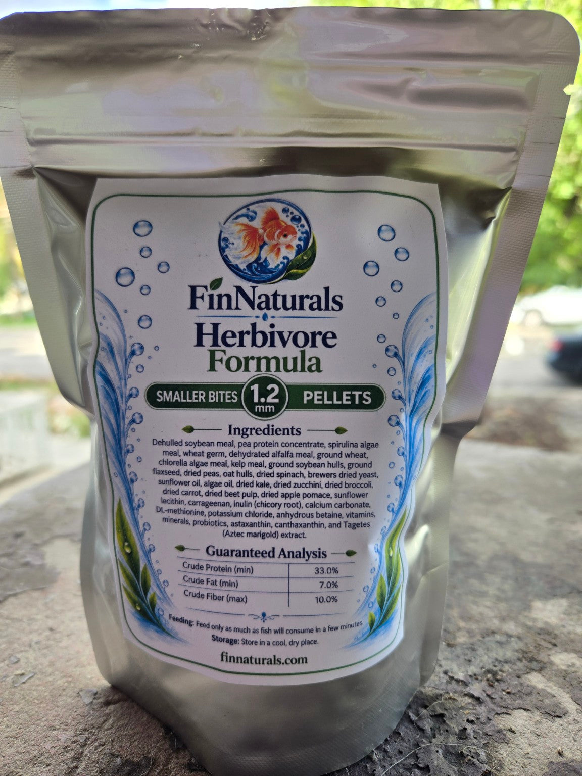 Actual Herbivore Smaller Bites Formula 1.2 mm pouch photographed outdoors, back label with ingredients and guaranteed analysis.