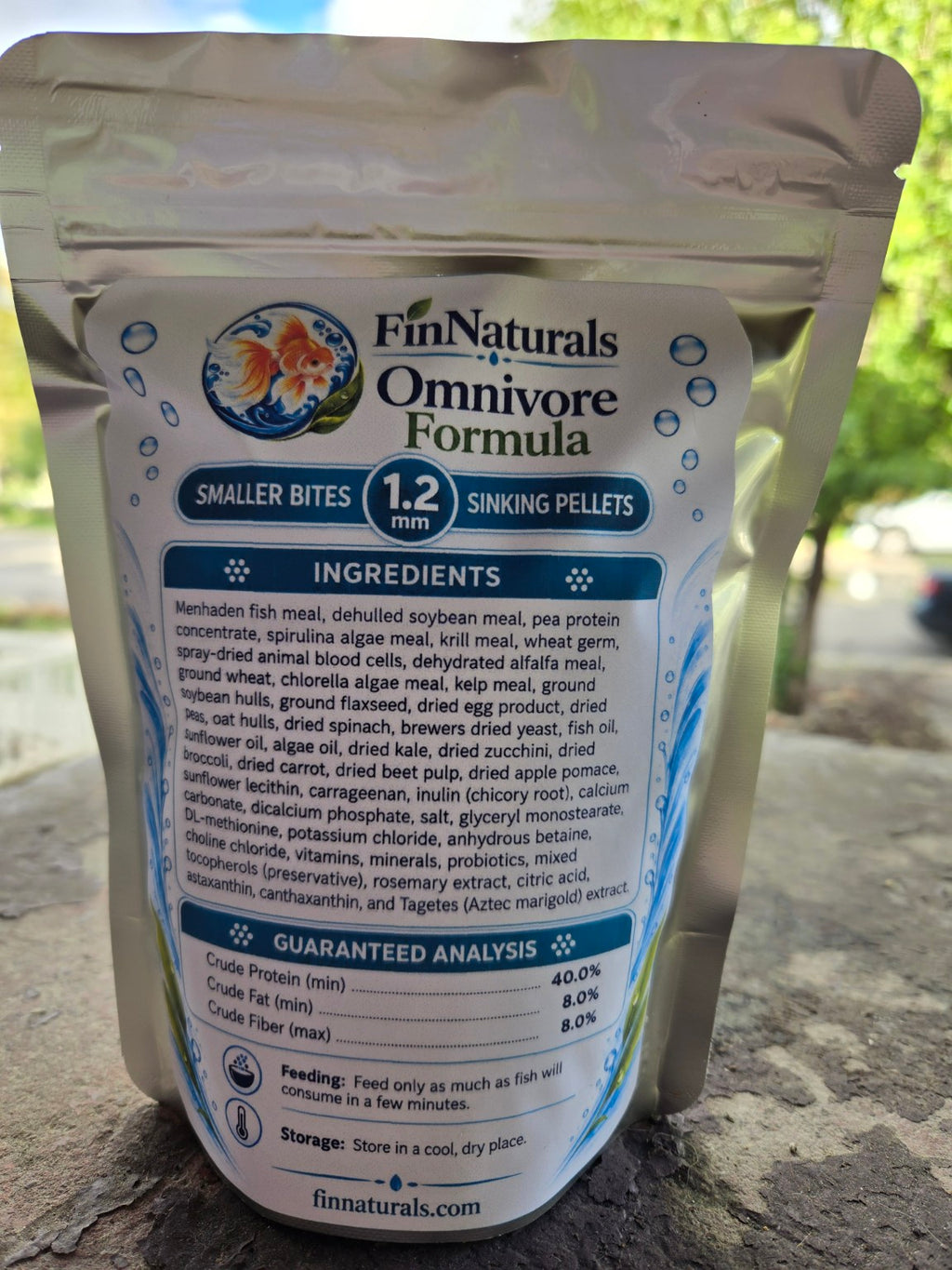 Actual Omnivore Smaller Bites Formula 1.2 mm pouch photographed outdoors, back label with ingredients and guaranteed analysis.